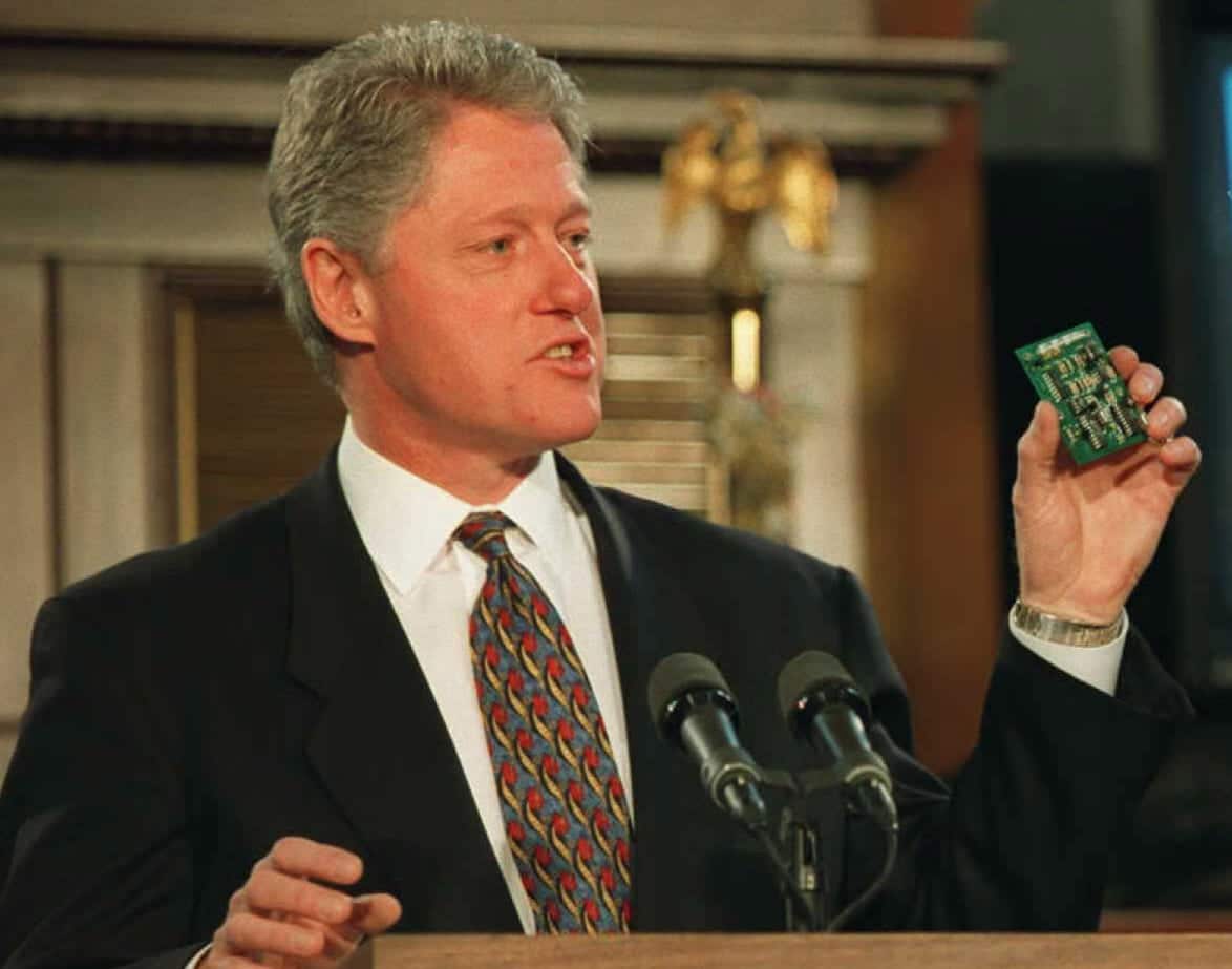 Le président américain Bill Clinton tient une puce V‑chip en 1996.